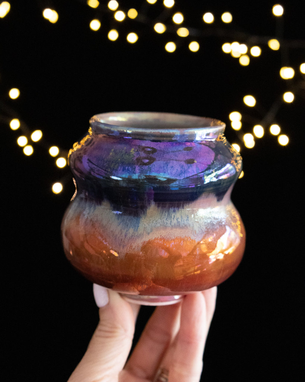 Handmade lusterware vase with a blue-violet collar over warm copper