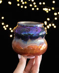 Handmade lusterware vase with a blue-violet collar over warm copper