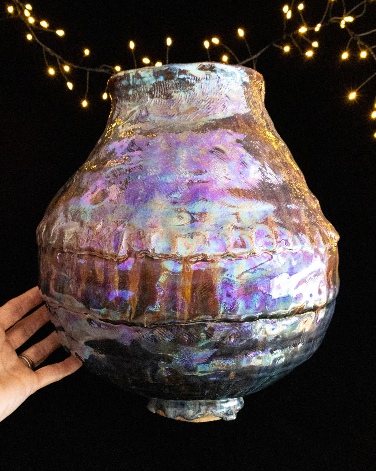 Large handmade lusterware pot held to show its scale
