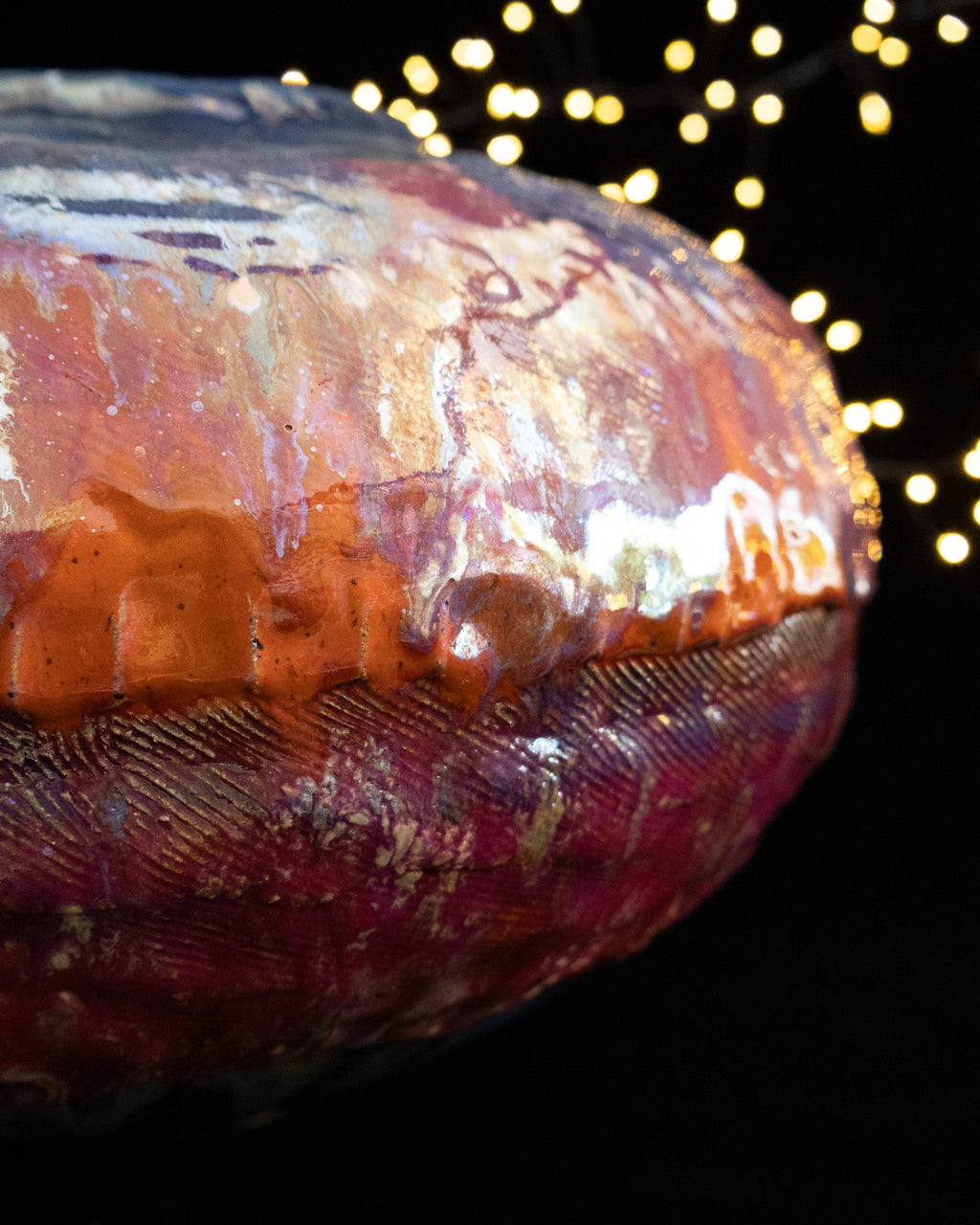 Close detail of rust and silver luster on a large ceramic pot
