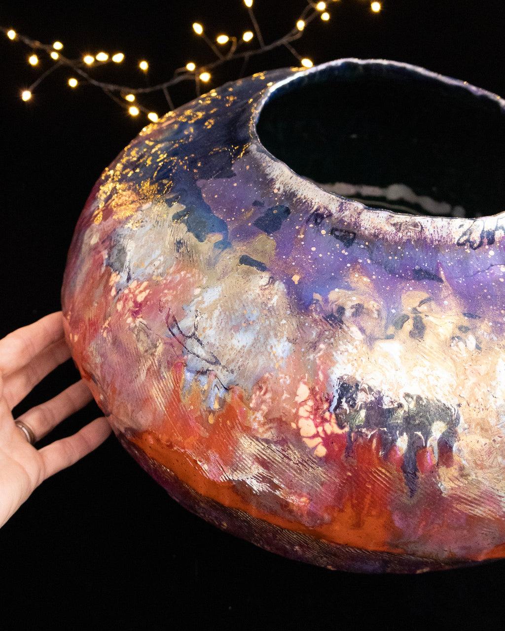 Wide shouldered lusterware pot held to show its scale