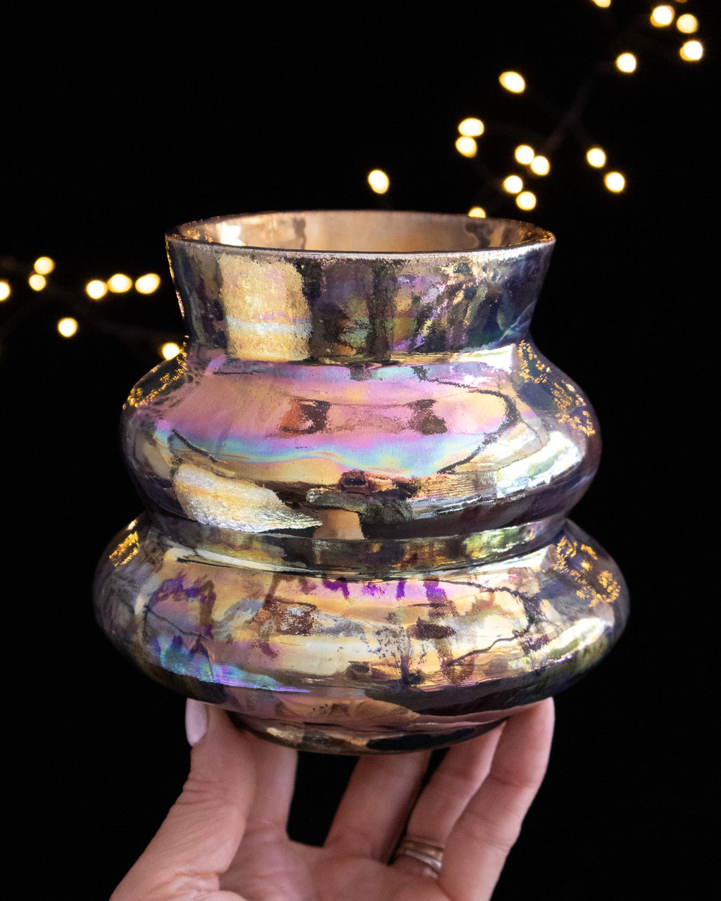 Three stacked bands catching iridescent light on a porcelain vase
