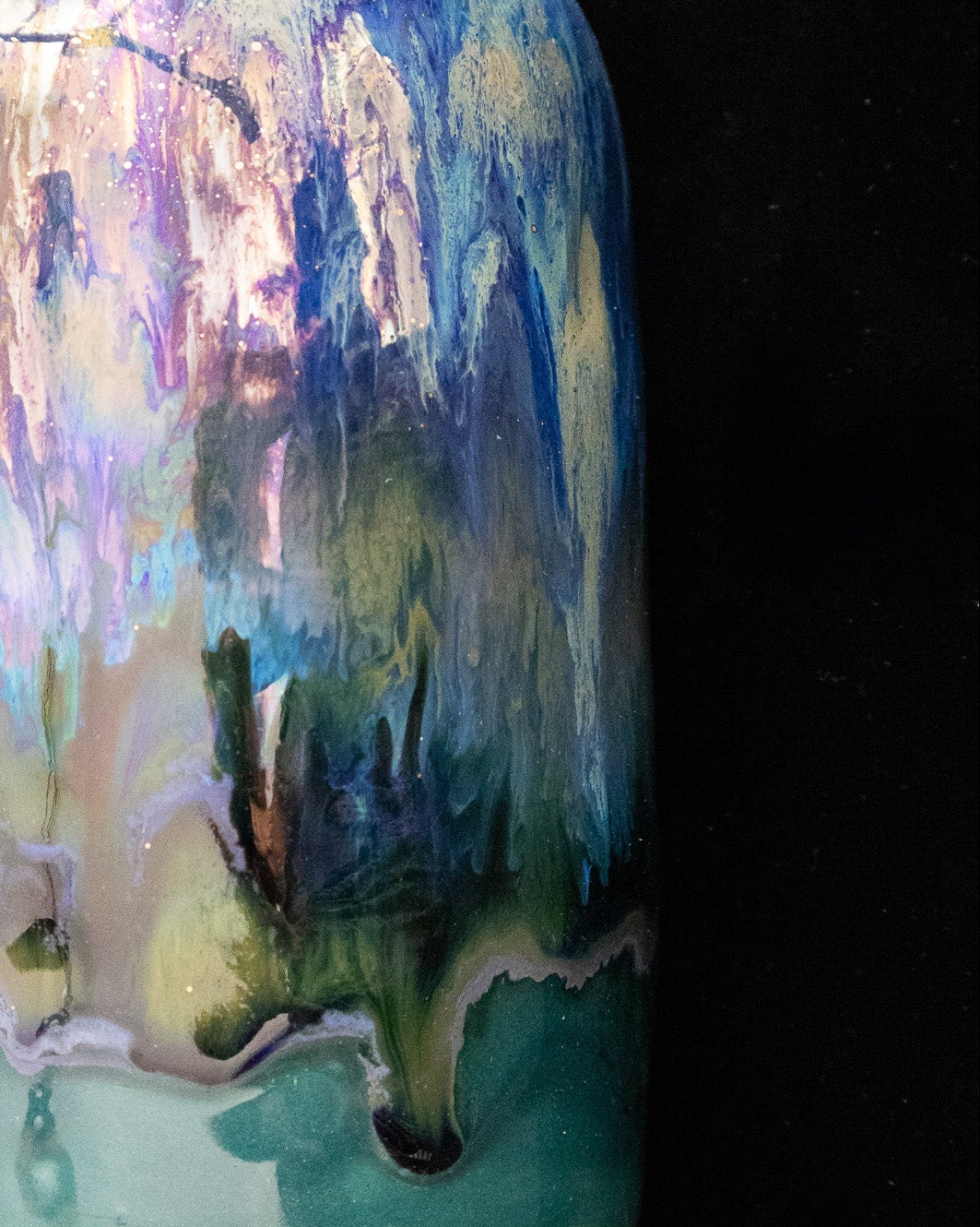 Iridescent violet and turquoise in-glaze luster on a handmade bottle