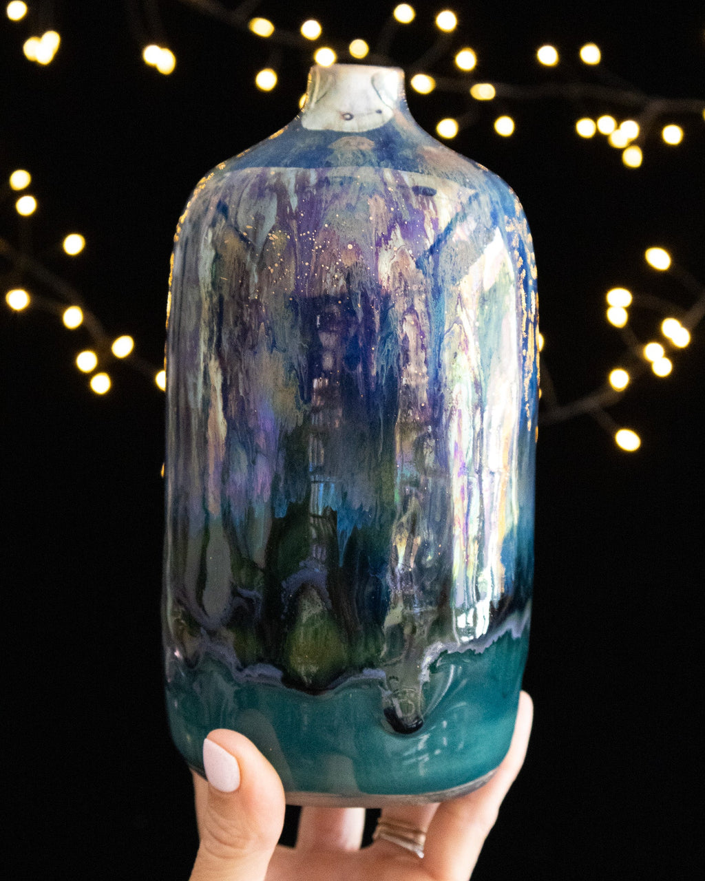 Hand thrown porcelain bottle with a turquoise band around the foot