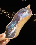 Hand pinched stoneware star seed pod with a cool silver and blue luster interior
