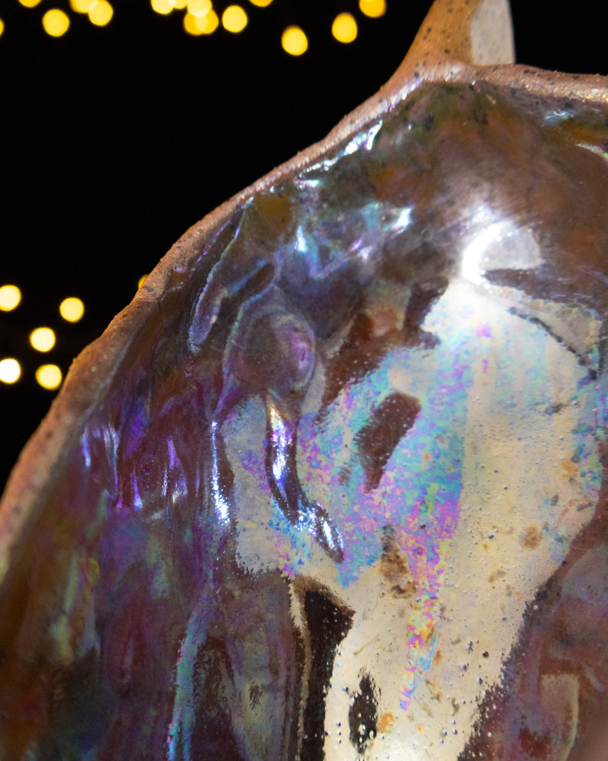 Close detail of blue-grey in-glaze luster inside a seed pod