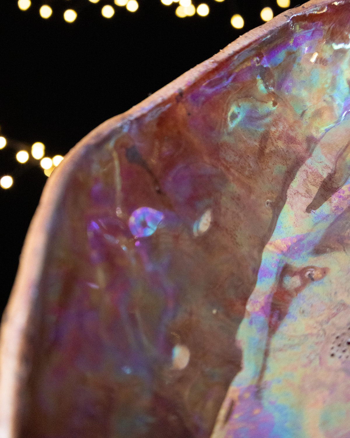 Close detail of violet and rose luster inside a ceramic seed pod