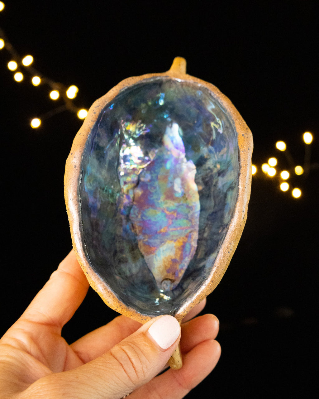 Hand pinched stoneware star seed pod with a deep blue luster interior