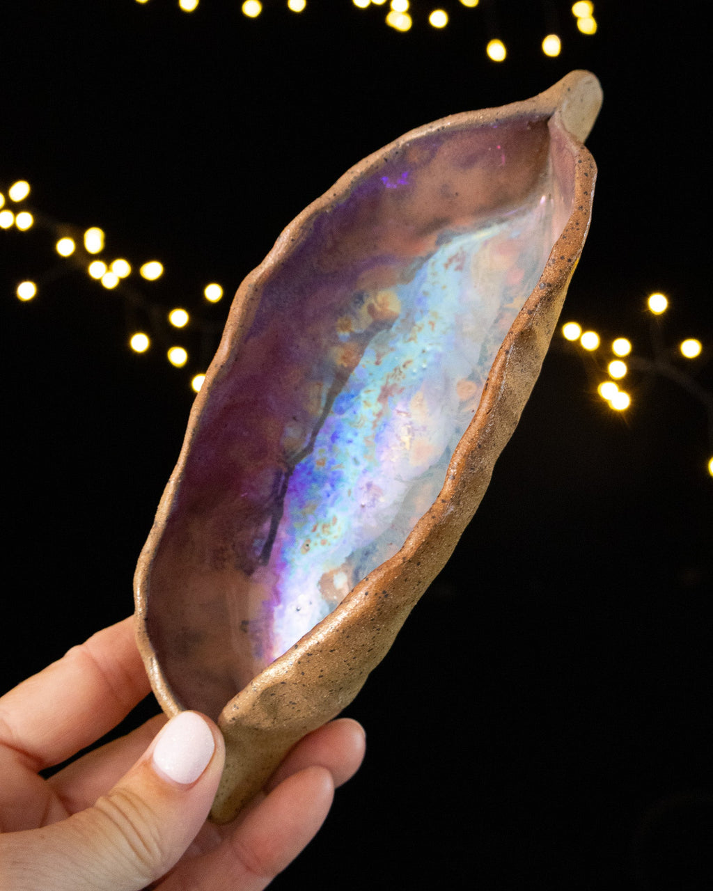 Hand pinched stoneware star seed pod with a violet and rose luster interior