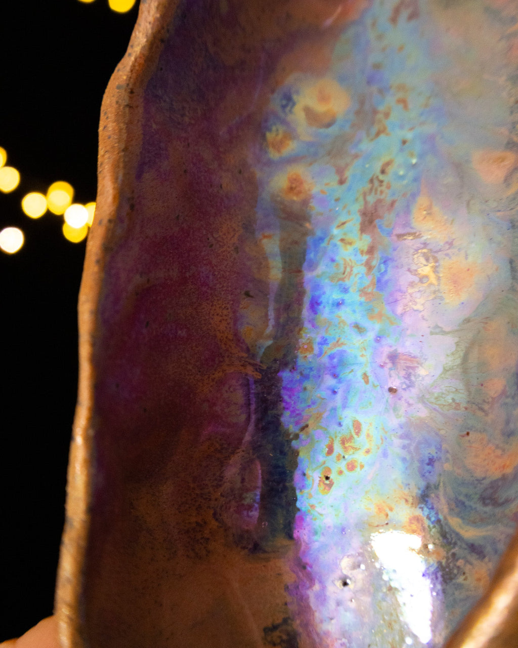 Close detail of violet fading to pale blue inside a ceramic seed pod
