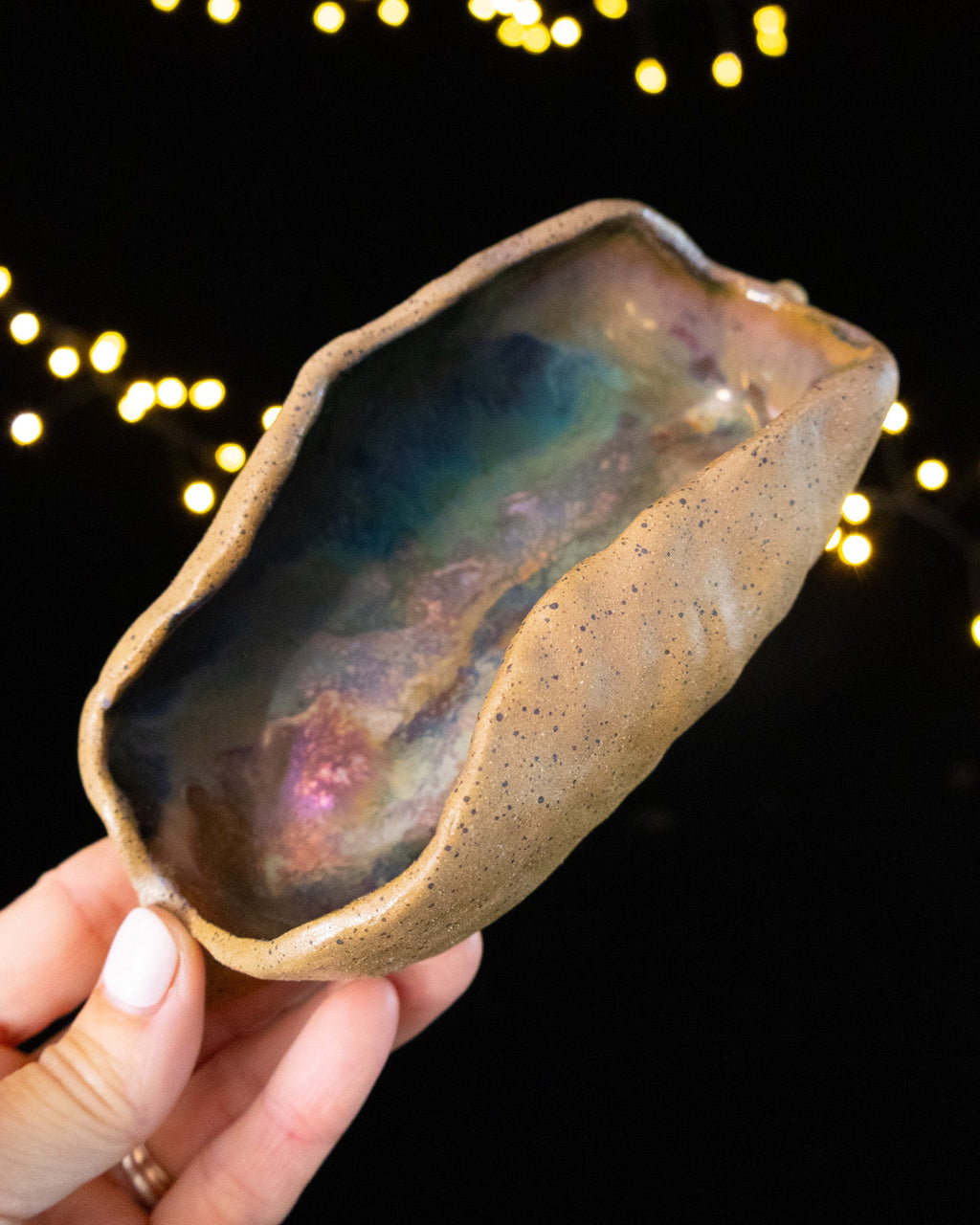 Hand pinched stoneware star seed pod with a deep teal and rust luster interior