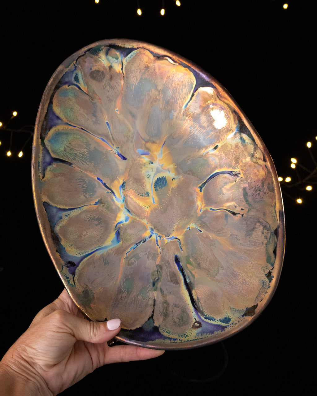 Very shallow hand built lusterware bowl with a lobed pattern in pale iridescence