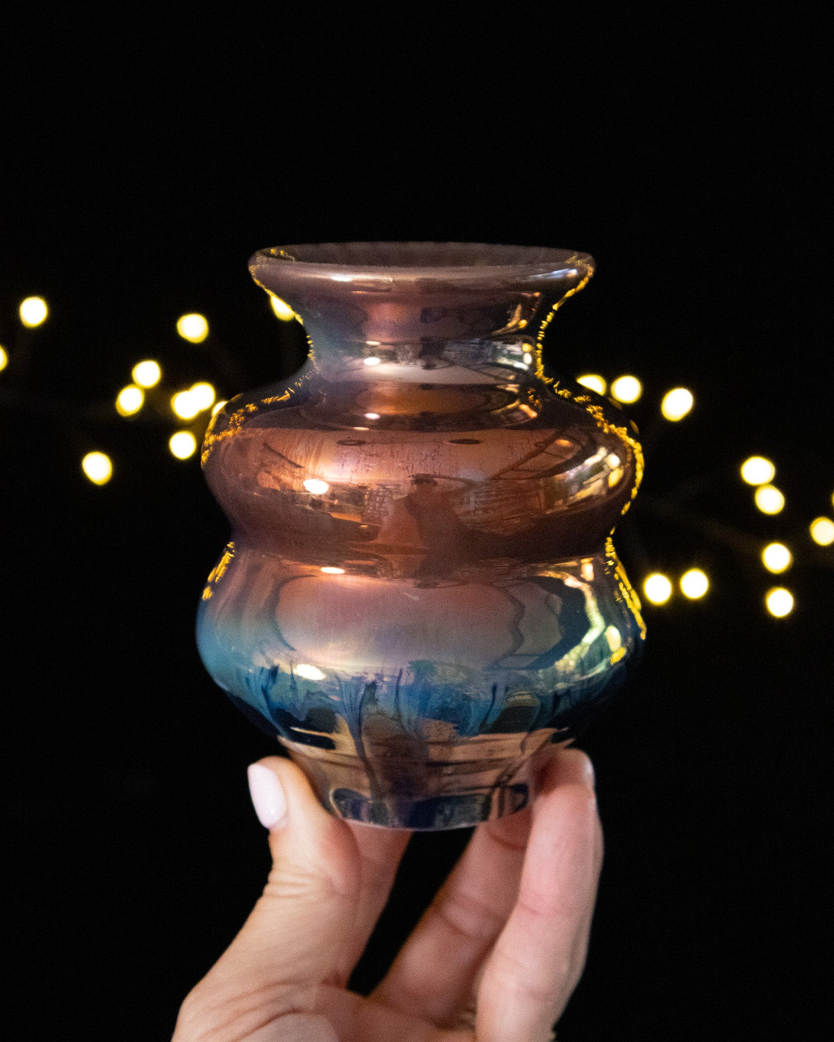 Handmade lusterware vase in warm copper above deep blue
