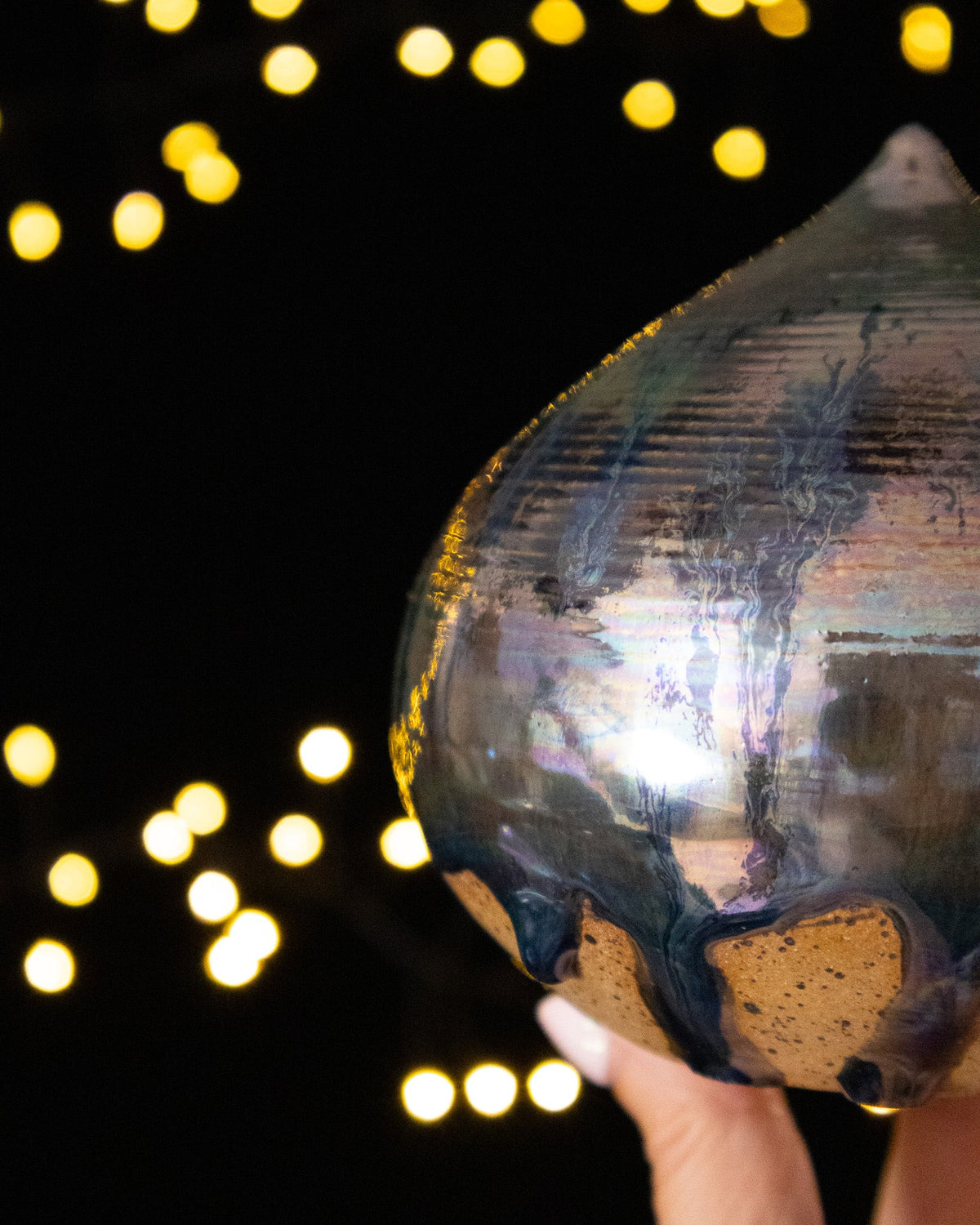 Close view of charcoal drips over silvery luster on a ceramic sound sculpture