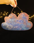 Cloud shaped ceramic jewelry wall display in rose, blue and violet luster, hanging from a leather cord