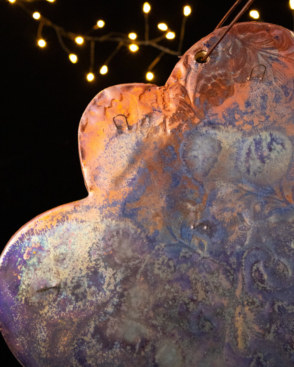Close view of the pressed floral pattern and hooks on a cloud jewelry display