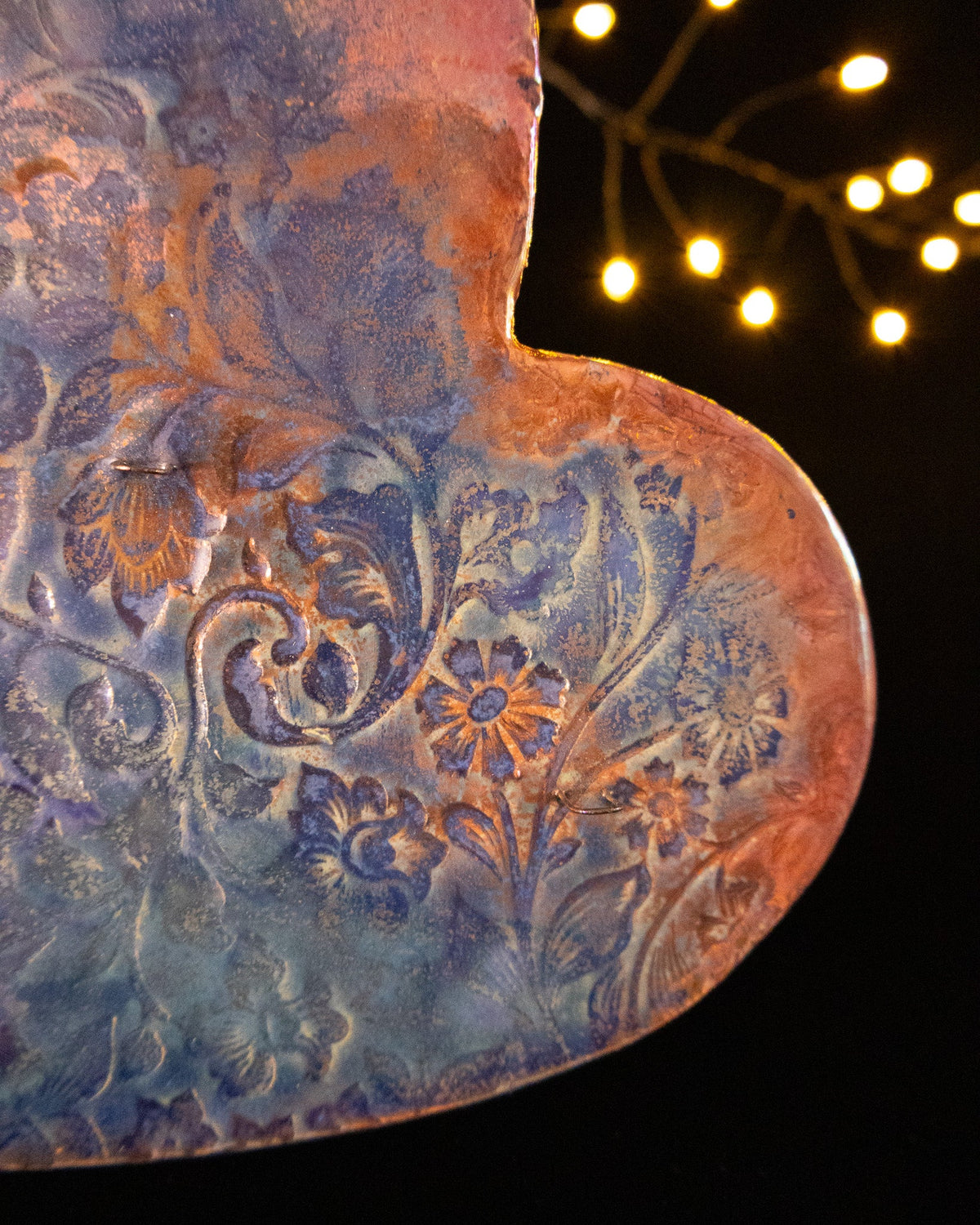 Detail of blue and violet luster over a pressed botanical pattern