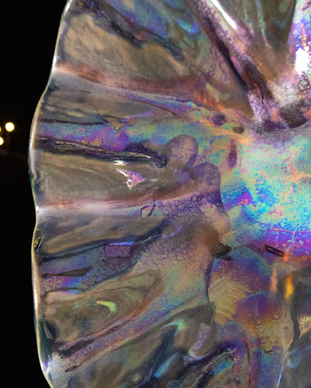 Close detail of rainbow flecks along the folds of a lusterware bloom