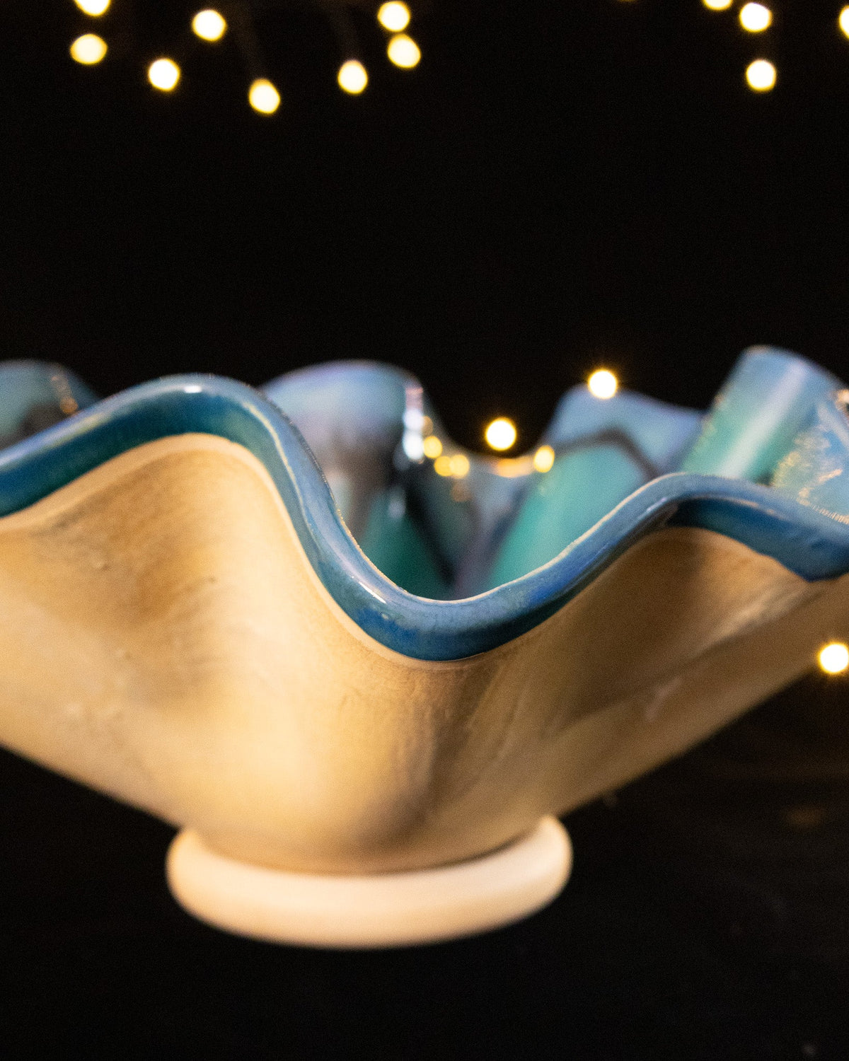 Side view of a bloom sculpture showing the cream exterior and small foot