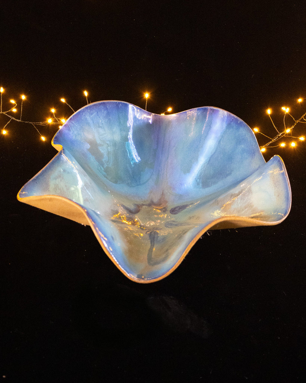 Blue bloom sculpture seen from the front with amber pooling at the centre
