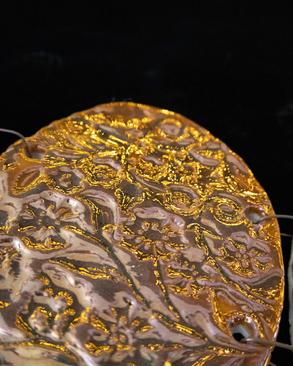 Close detail of the pressed botanical pattern on a lusterware chime panel