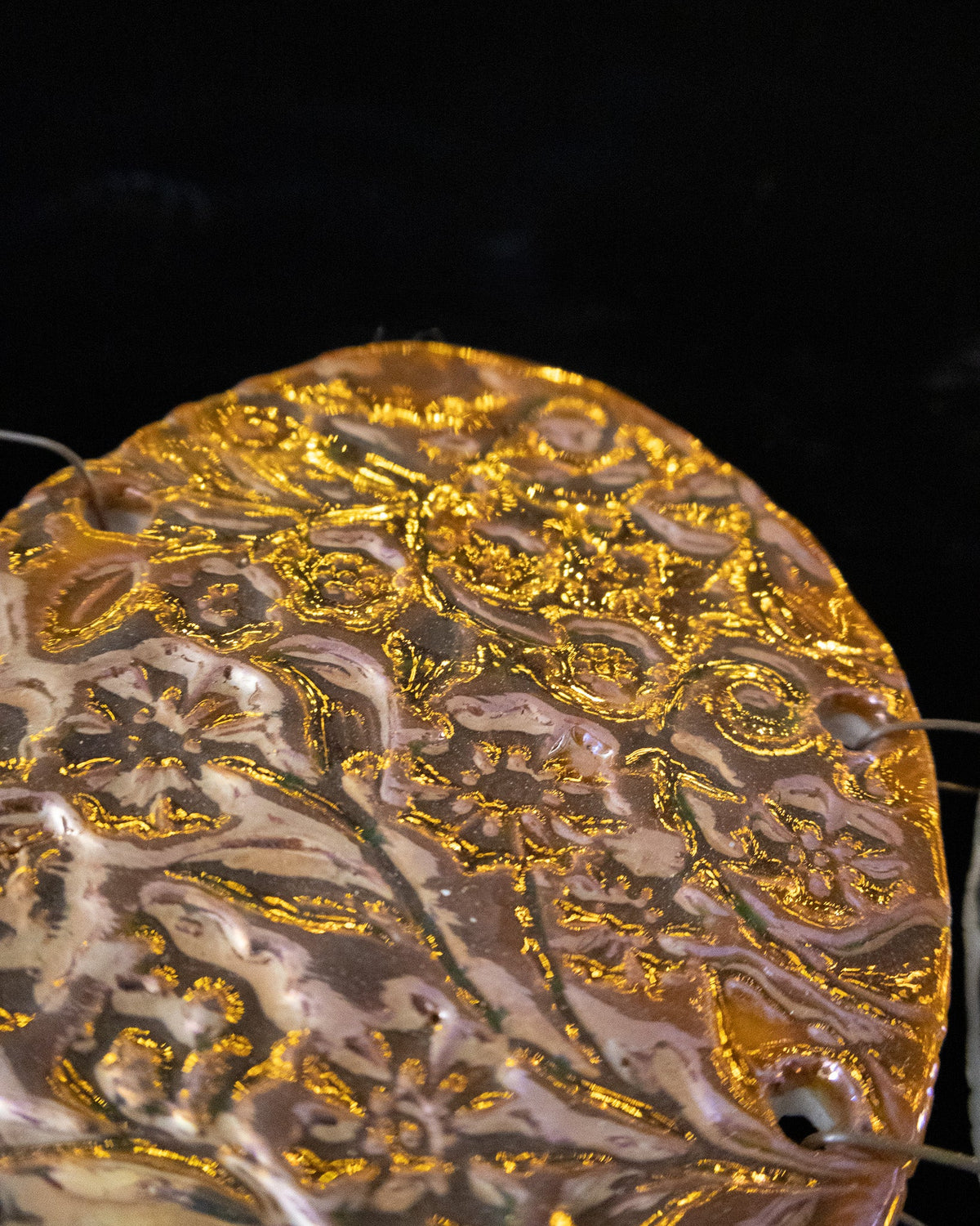 Close detail of the pressed botanical pattern on a lusterware chime panel
