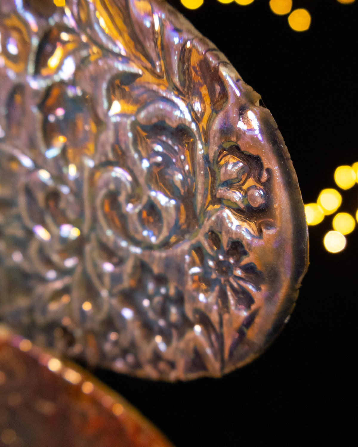 Close detail of warm rose luster over a pressed ceramic panel