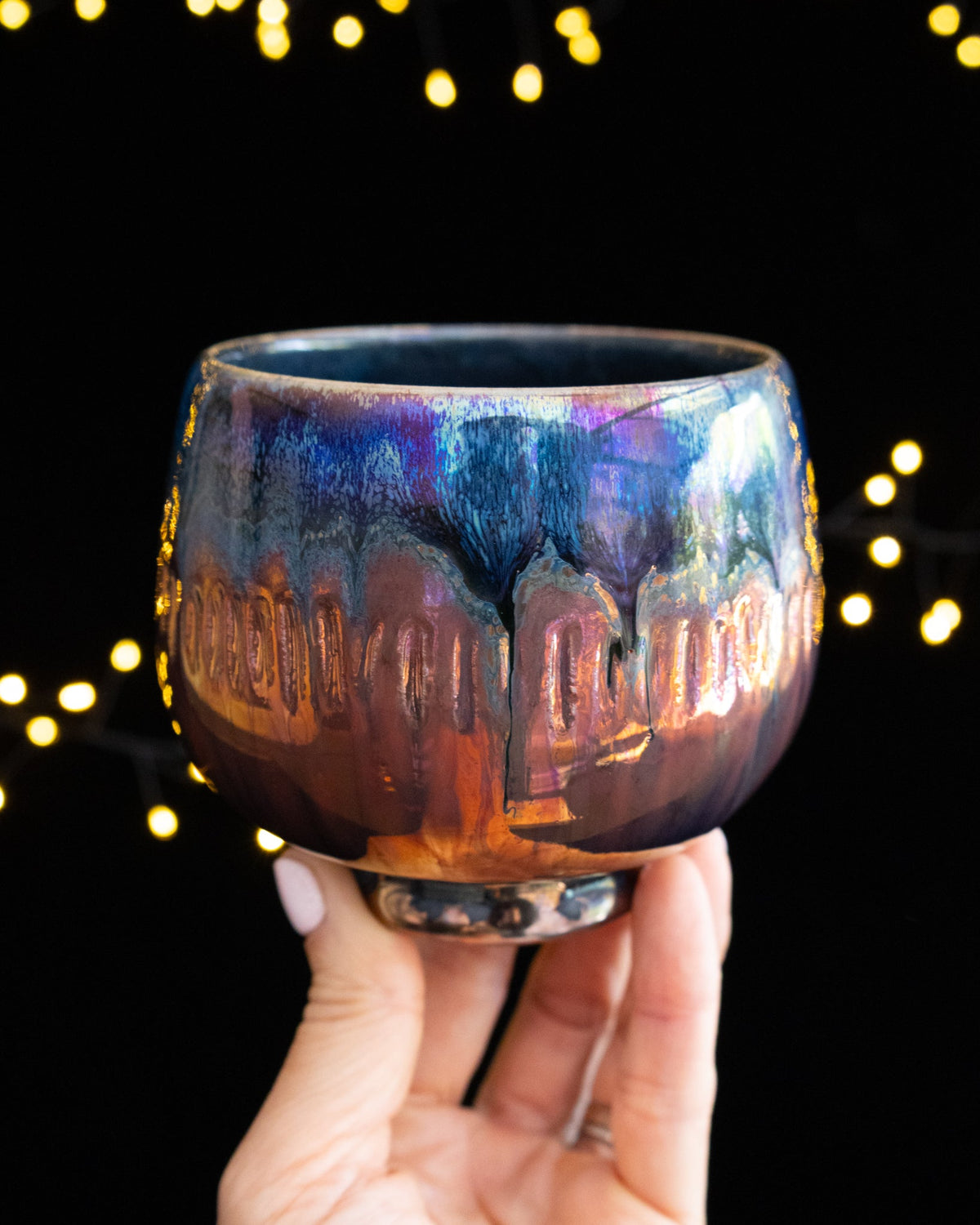 Iridescent blue and amber in-glaze luster on a wheel thrown porcelain cup