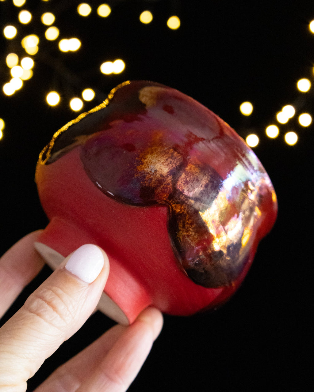 Angled view of a garnet and coral lusterware ritual cup