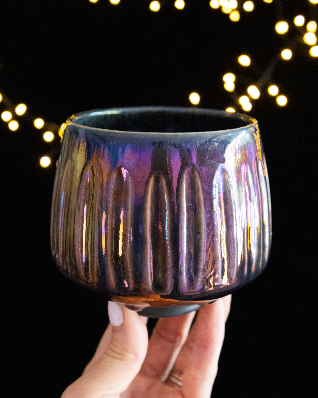 Carved vertical fluting catching the light on iridescent porcelain