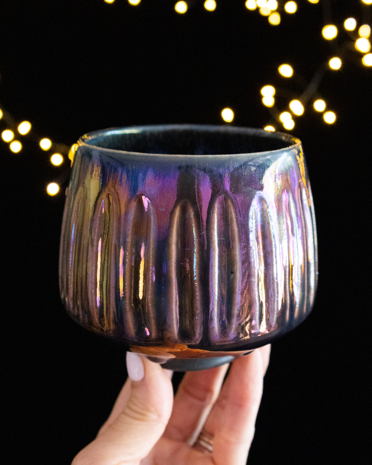 Carved vertical fluting catching the light on iridescent porcelain
