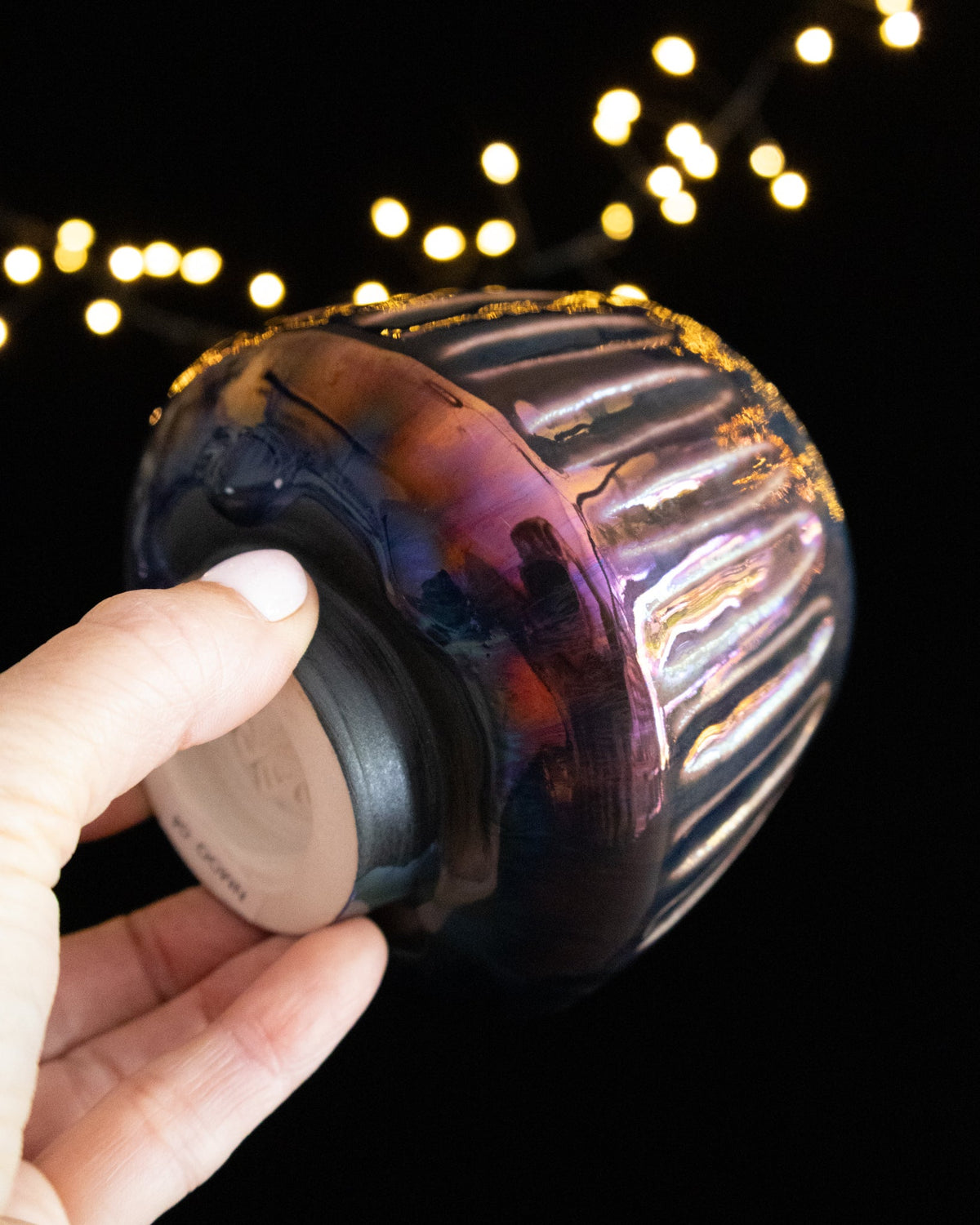 Angled view of a fluted lusterware ritual cup showing the foot