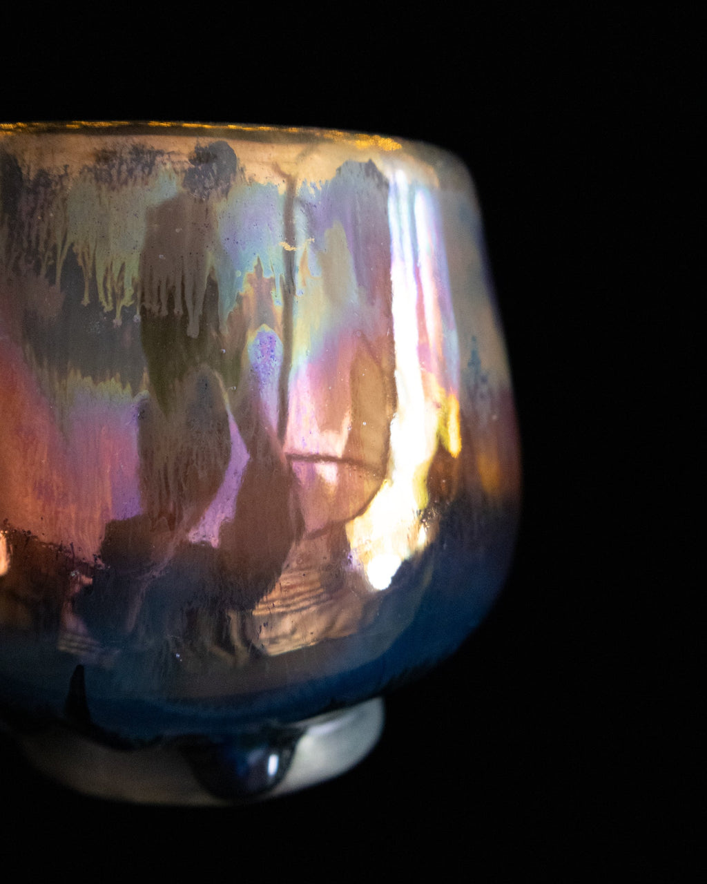 Close detail of shifting rose and blue luster on handmade ceramics