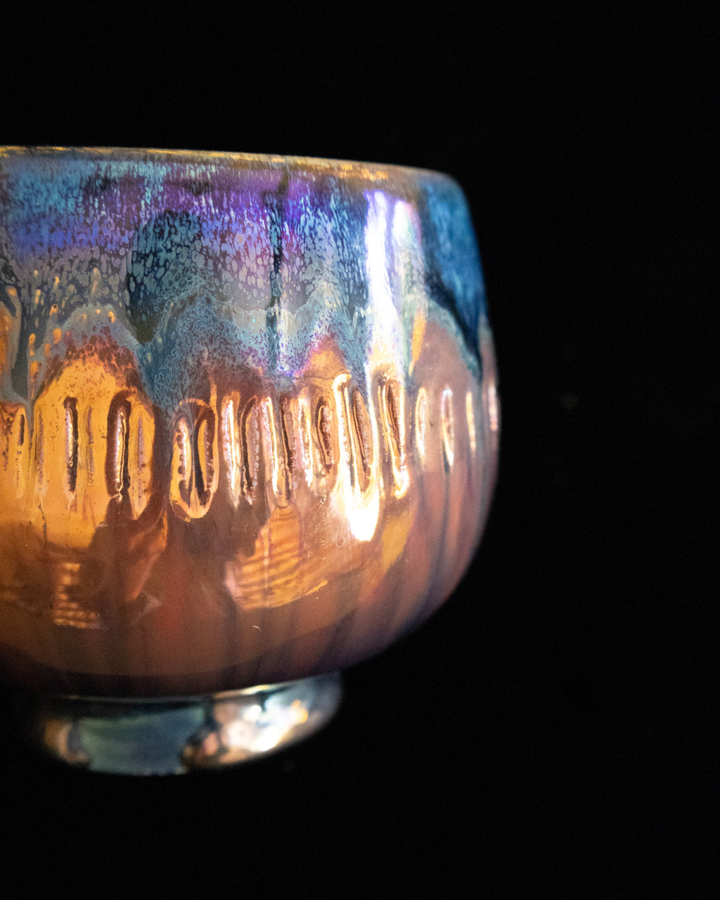 Close detail of blue and amber luster glaze on handmade porcelain