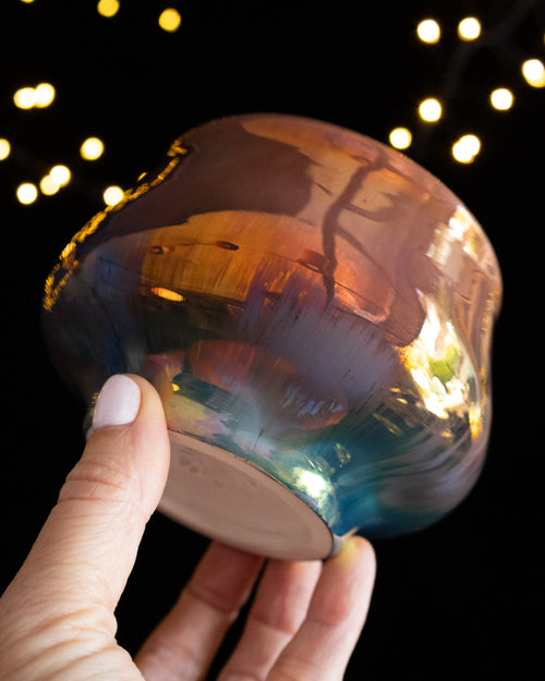 Angled view of an amber lusterware ritual cup showing the foot