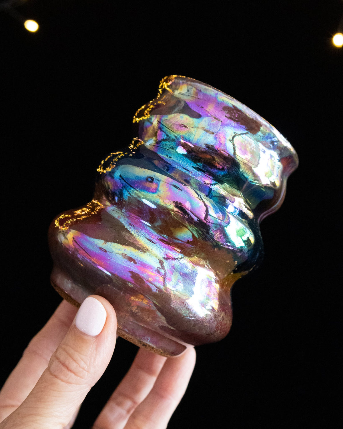 Angled view of a stacked curvy lusterware cup